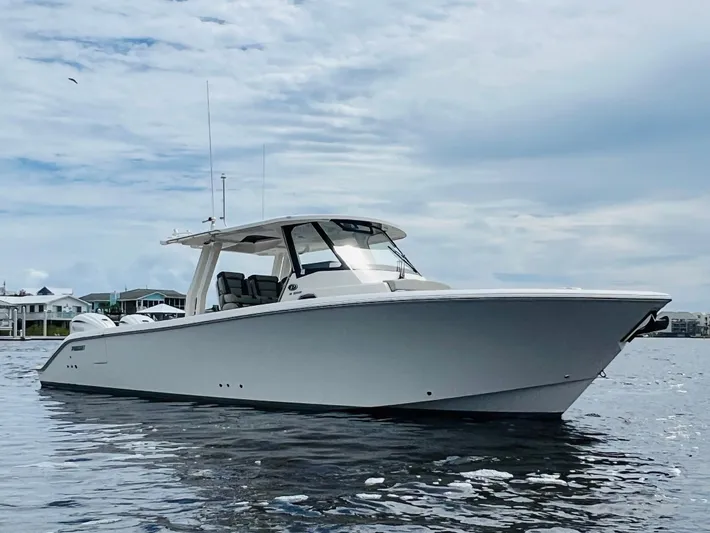  Yacht Photos Pics 2022 Pursuit S 358 Sport boat on calm water under cloudy sky.