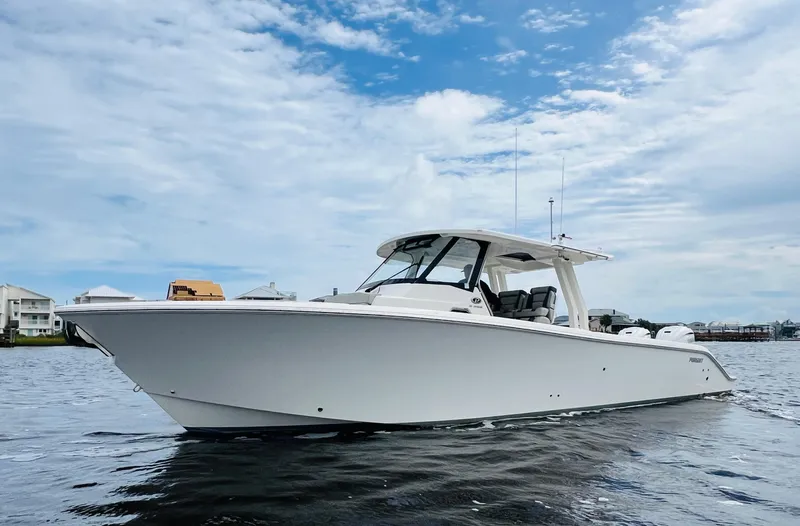  Yacht Photos Pics 2022 Pursuit S 358 Sport boat on calm water under a partly cloudy sky.
