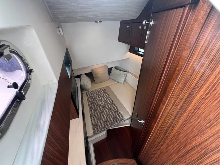 Yacht Photos Pics 2022 Pursuit S 358 Sport cabin interior with cozy seating and wooden finishes.