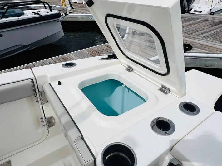  Yacht Photos Pics 2022 Pursuit S 358 Sport boat with open storage compartment at dock.