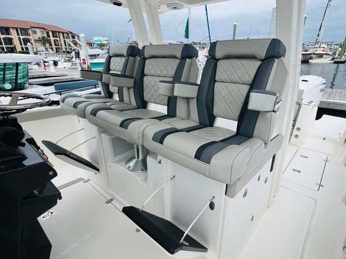  Yacht Photos Pics 2022 Pursuit S 358 Sport boat with luxurious seating at a marina.