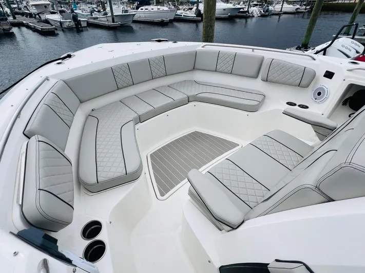  Yacht Photos Pics 2022 Pursuit S 358 Sport boat with spacious, luxurious seating in a marina setting.