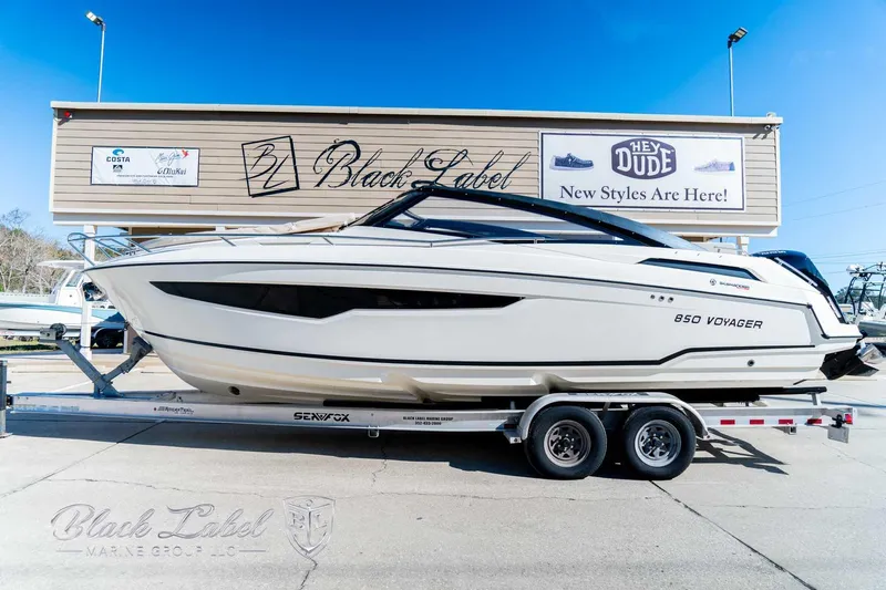 Ocean Phantom Yacht Photos Pics 2023 Hussar 850 boat on trailer, displayed outdoors near Black Label store.
