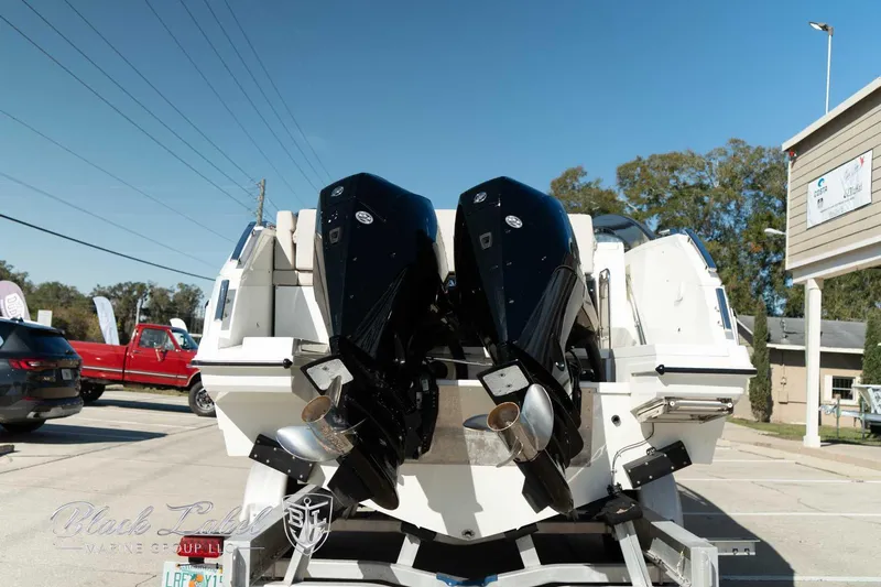 Ocean Phantom Yacht Photos Pics 2023 Hussar 850 boat with dual outboard motors, parked outdoors on a sunny day.