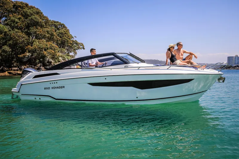 Ocean Phantom Yacht Photos Pics 2023 Hussar 850 Voyager boat cruising on clear water with passengers enjoying the sun.