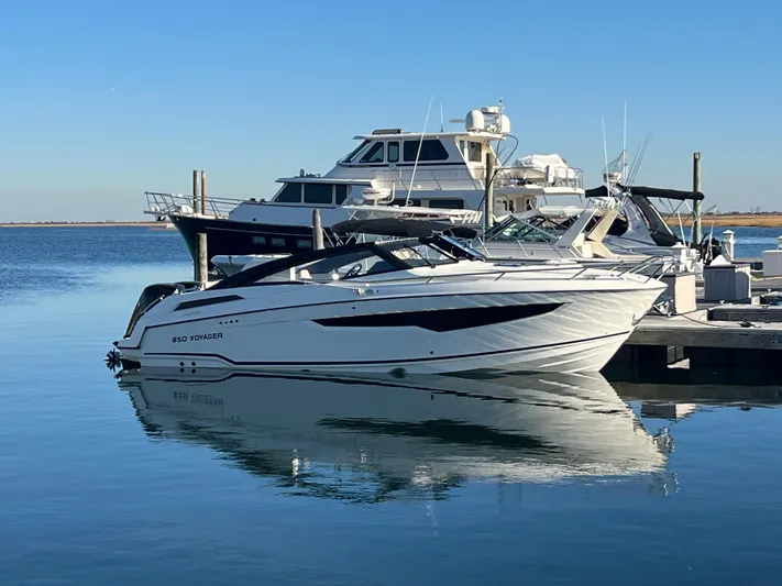 Ocean Phantom Yacht Photos Pics 2023 Hussar 850 boat docked at marina, reflecting on calm water.