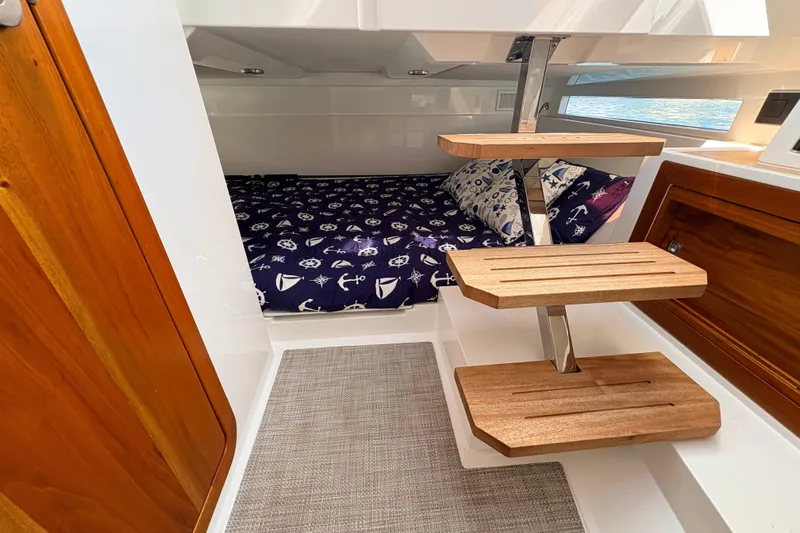 Casa - Ashanty Yacht Photos Pics Interior of 2025 De Antonio Yachts D32, featuring a cozy cabin with nautical-themed bedding.