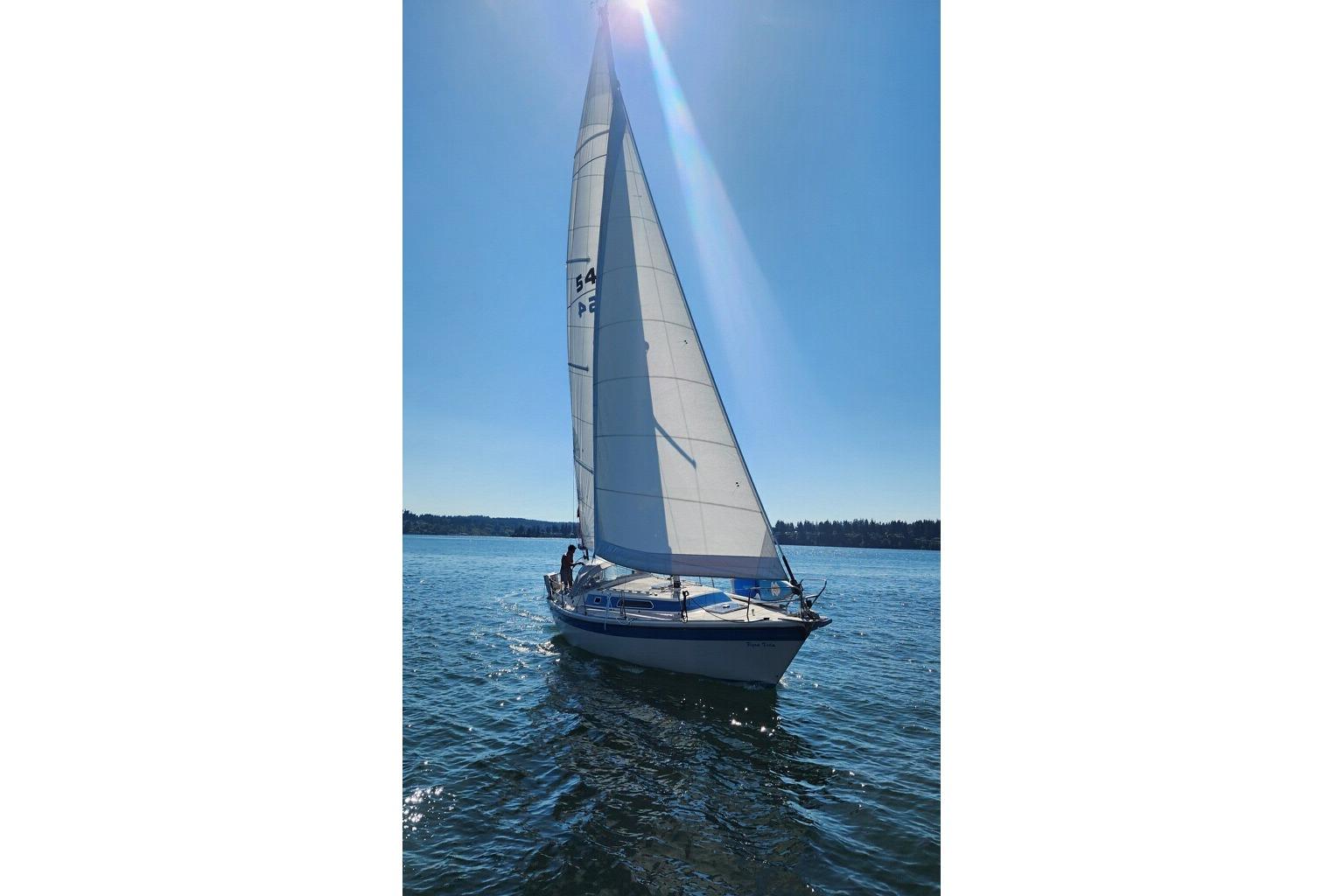 1985 Dehler 372 sailboat gliding on a sunny day with full sails.