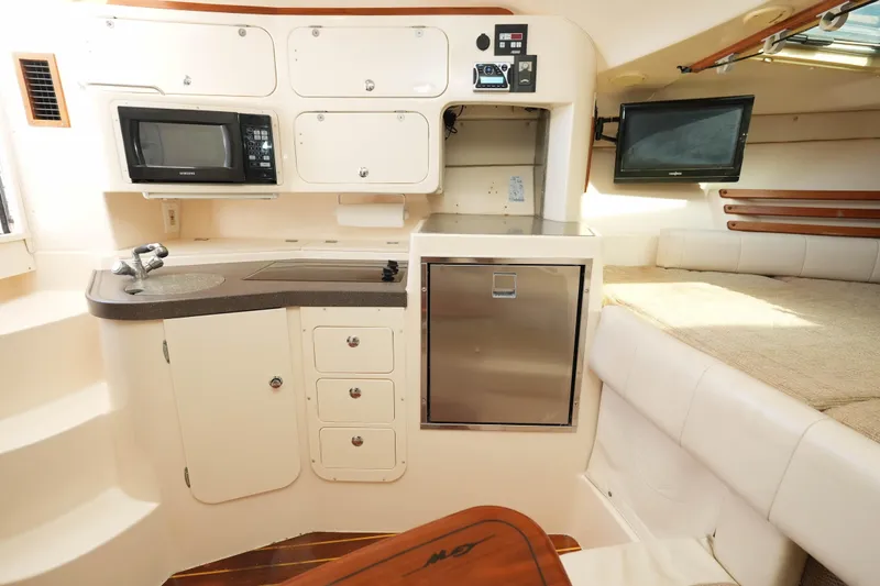  Yacht Photos Pics 2003 Grady-White Express 330 cabin interior with kitchenette, microwave, and seating area.