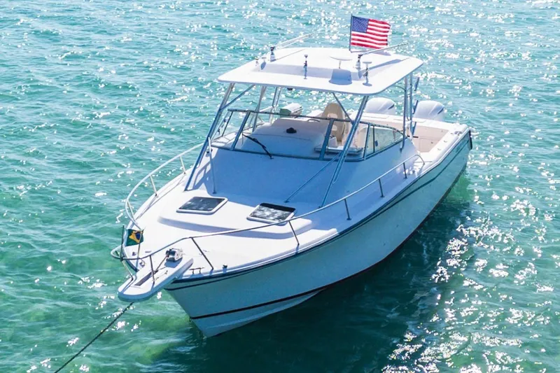  Yacht Photos Pics 2003 Grady-White Express 330 boat on sparkling turquoise water with American flag.