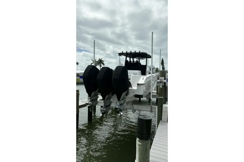  Yacht Photos Pics 2024 Fountain 32 NX Sportfish boat docked with triple outboard engines.