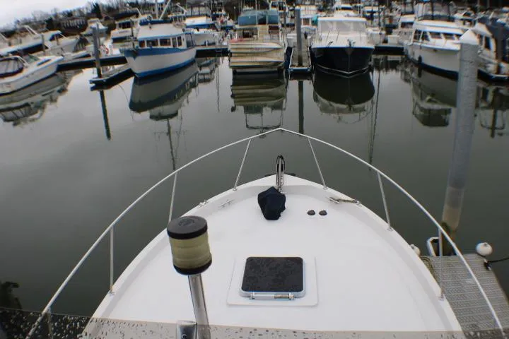 1986 Lynnwood Flybridge Sedan docked in a marina, surrounded by other boats.