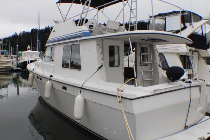 1986 Lynnwood Flybridge Sedan docked at marina, featuring classic design and spacious deck.