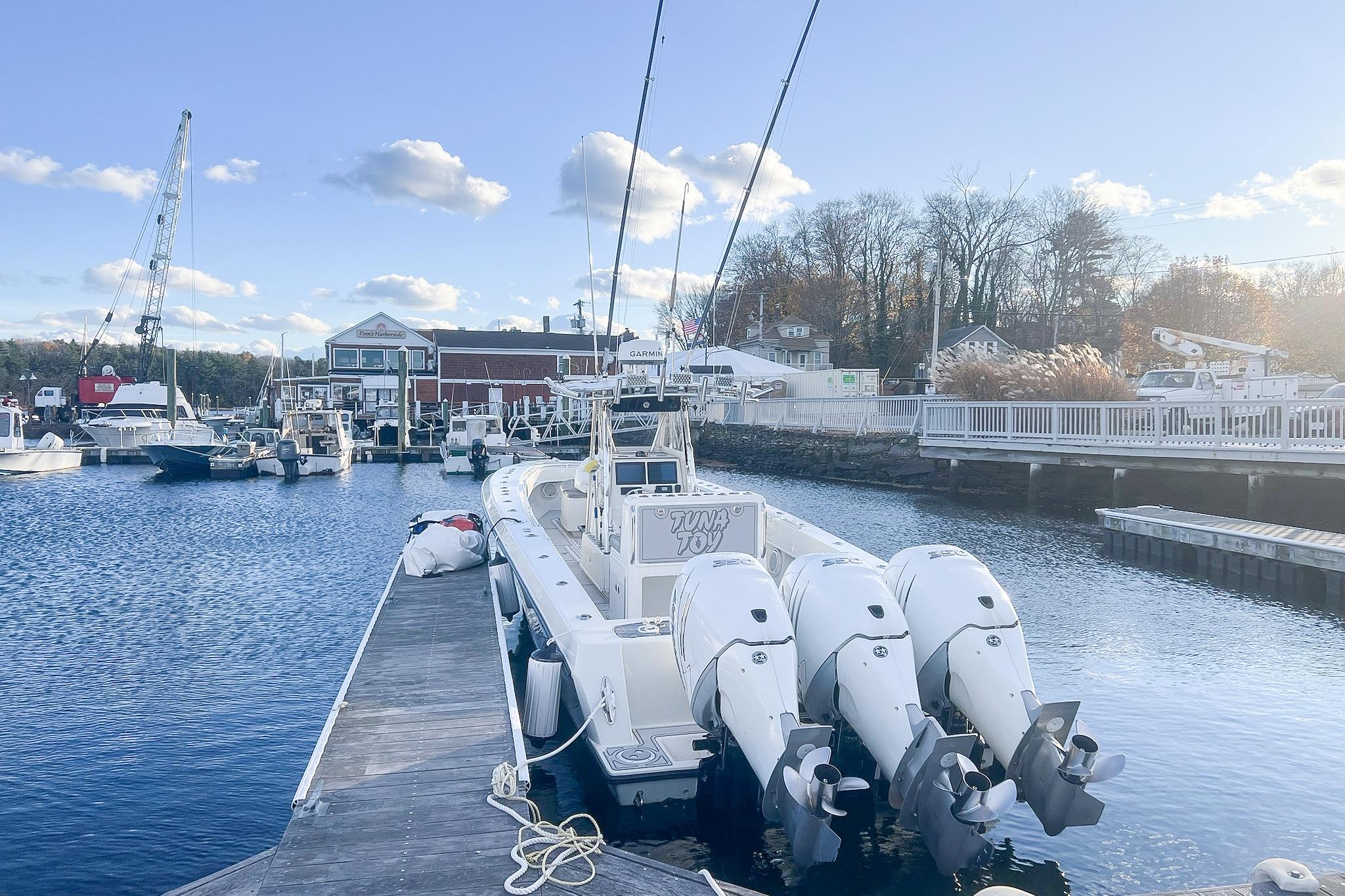 2002 Contender 36 Open boat docked at marina with triple outboard engines.