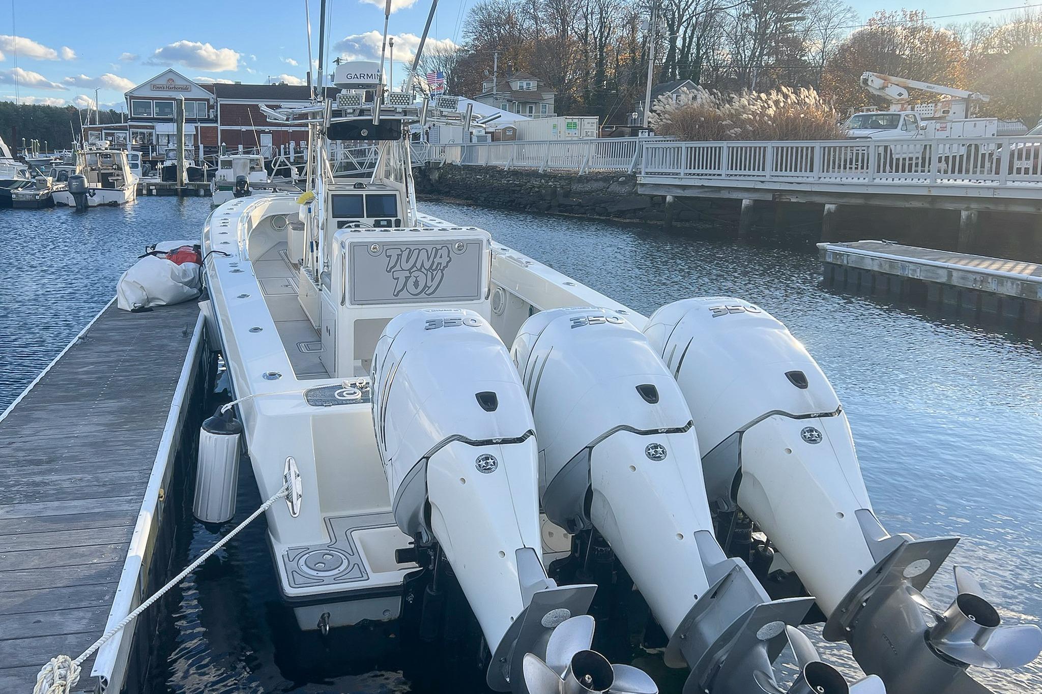 2002 Contender 36 Open boat docked with triple outboard engines.