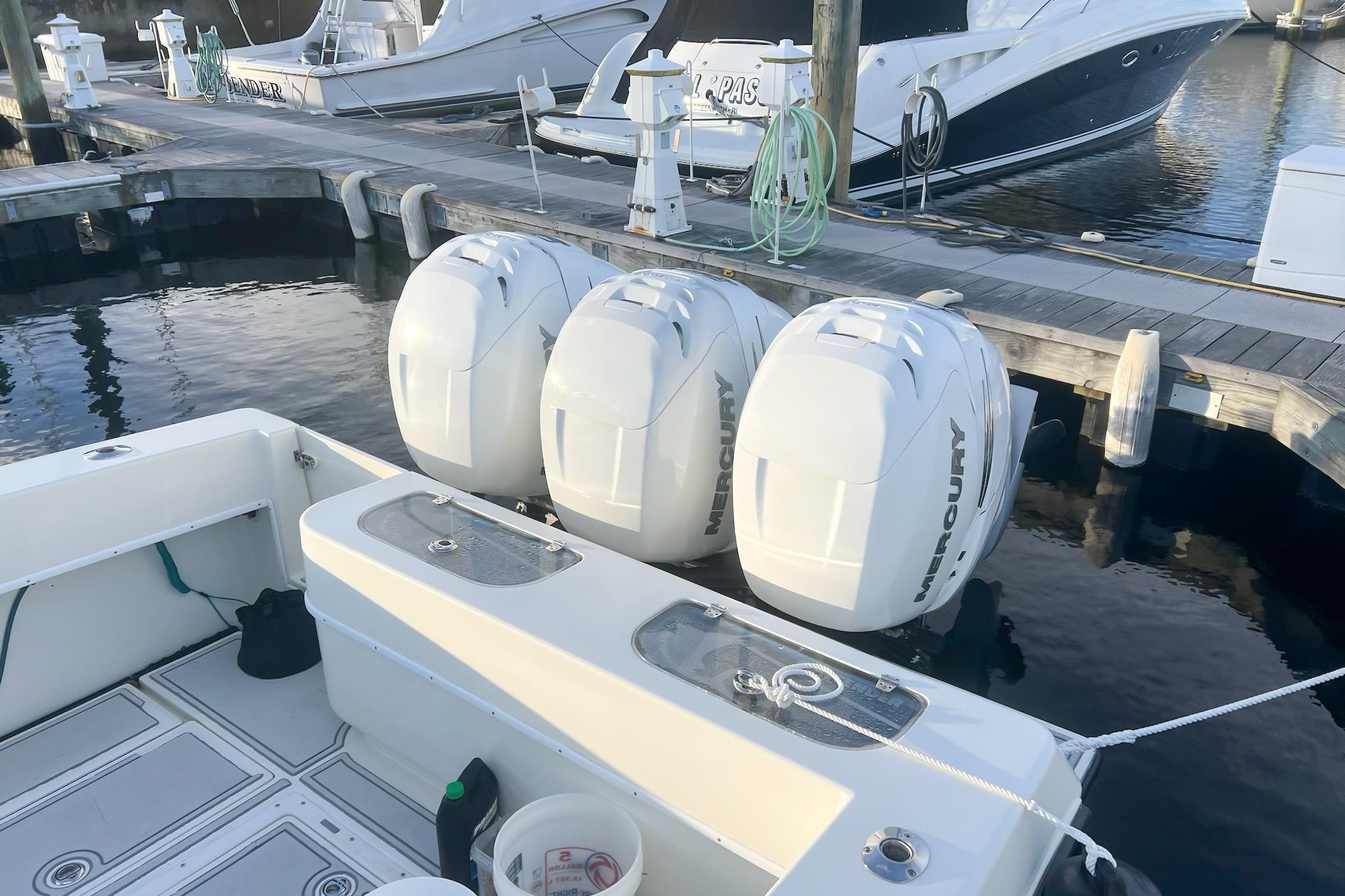 2002 Contender 36 Open with triple Mercury outboard engines docked at marina.