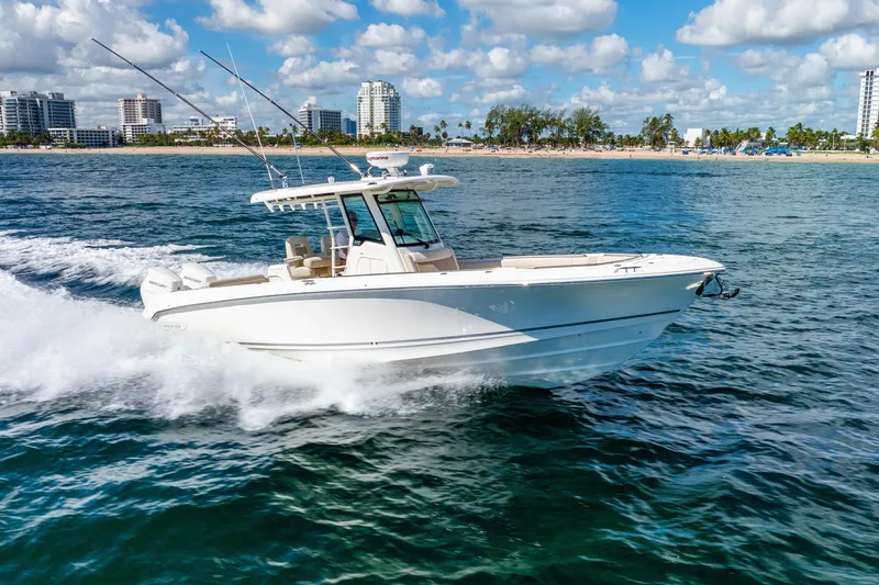 Bwce0715h122 Yacht Photos Pics 2022 Boston Whaler 330 Outrage cruising on ocean near city skyline.