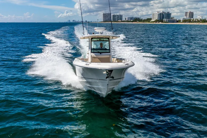 Bwce0715h122 Yacht Photos Pics 2022 Boston Whaler 330 Outrage cruising on open water near city skyline.