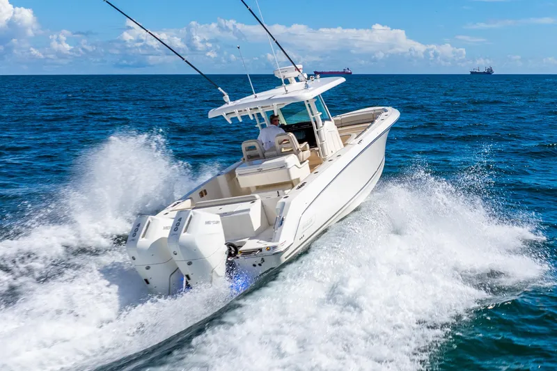 Bwce0715h122 Yacht Photos Pics 2022 Boston Whaler 330 Outrage cruising on open ocean, creating dynamic water splashes.
