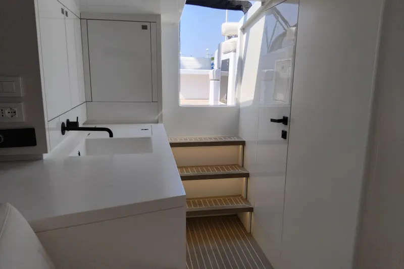  Yacht Photos Pics Interior of 2024 VanDutch 40 yacht with modern white kitchen and stairs.