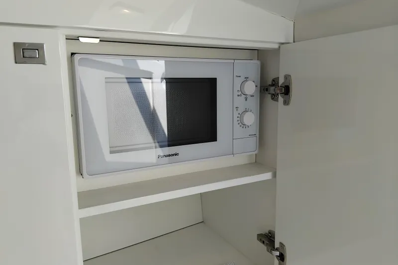  Yacht Photos Pics Built-in Panasonic microwave in 2024 VanDutch 40 yacht's sleek white cabinet.