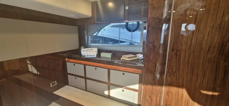 In Stock Yacht Photos Pics Interior of 2025 Fairline Targa 45 Open yacht with wood finish and storage cabinets.
