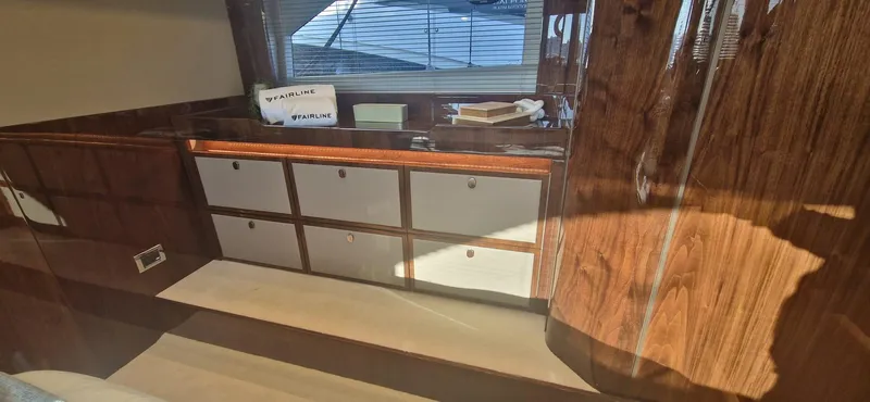 In Stock Yacht Photos Pics Interior of 2025 Fairline Targa 45 Open yacht with wooden cabinetry and window view.