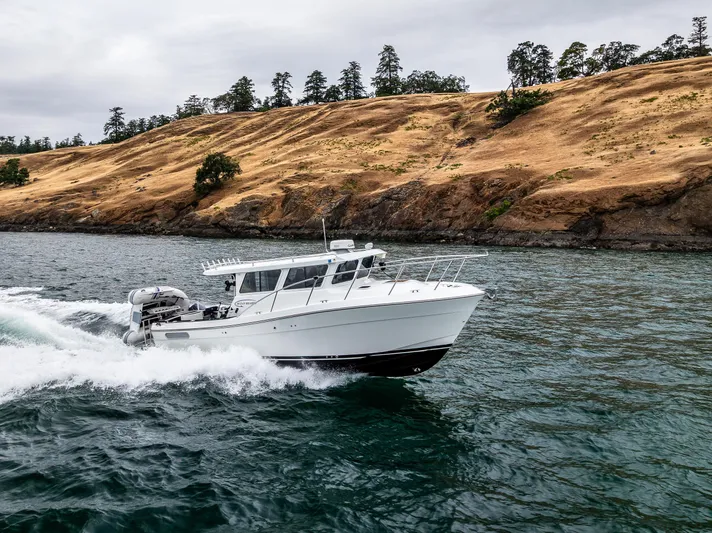 Ocean Roamer Yacht Photos Pics 2016 Lindell Ocean Roamer cruising near rocky shoreline under cloudy sky.