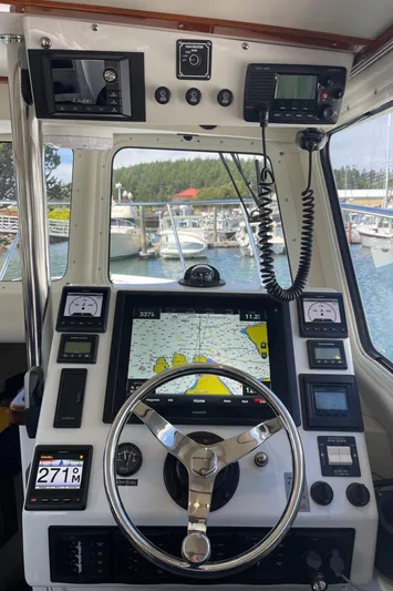 Ocean Roamer Yacht Photos Pics Control panel of a 2016 Lindell Ocean Roamer boat with navigation equipment and steering wheel.