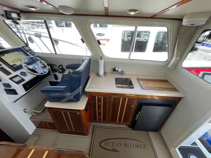 Ocean Roamer Yacht Photos Pics Interior of 2016 Lindell Ocean Roamer boat with helm, sink, and wooden cabinetry.