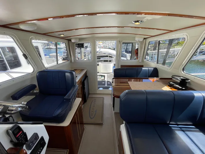 Ocean Roamer Yacht Photos Pics Interior of 2016 Lindell Ocean Roamer boat with blue seating and wooden accents.