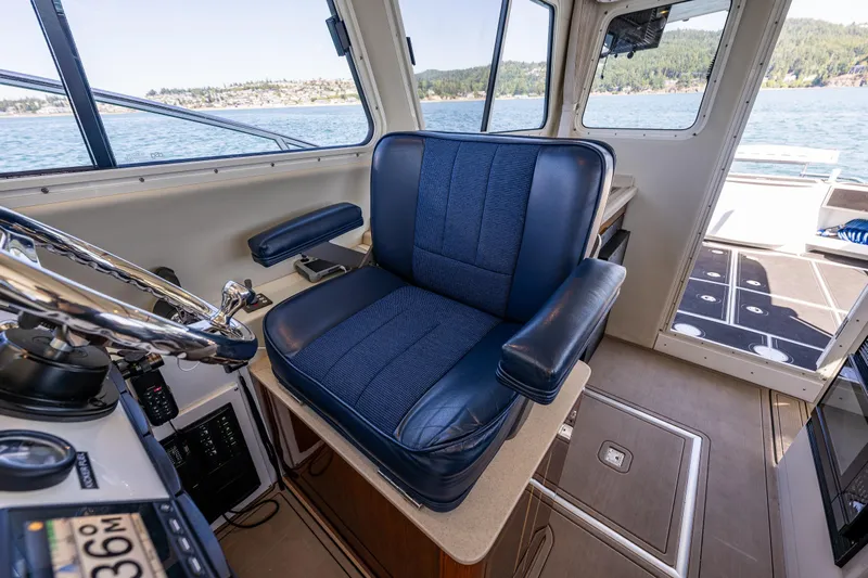 Ocean Roamer Yacht Photos Pics Captain's chair in 2016 Lindell Ocean Roamer boat cockpit, overlooking scenic waters.