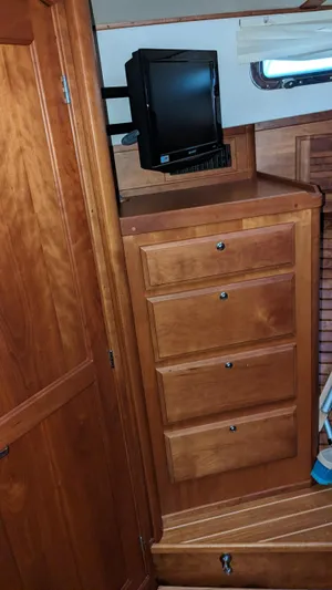 Sea Ranger Yacht Photos Pics 2008 Sabre 34 Express cabin interior with wooden drawers and a small TV.