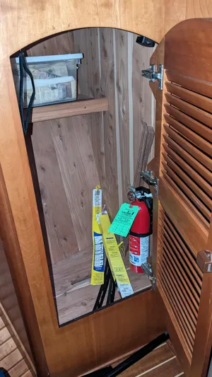 Sea Ranger Yacht Photos Pics Open wooden cabinet on a 2008 Sabre 34 Express boat with fire extinguisher and supplies.