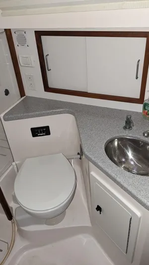 Sea Ranger Yacht Photos Pics 2008 Sabre 34 Express boat bathroom with toilet, sink, and storage cabinets.