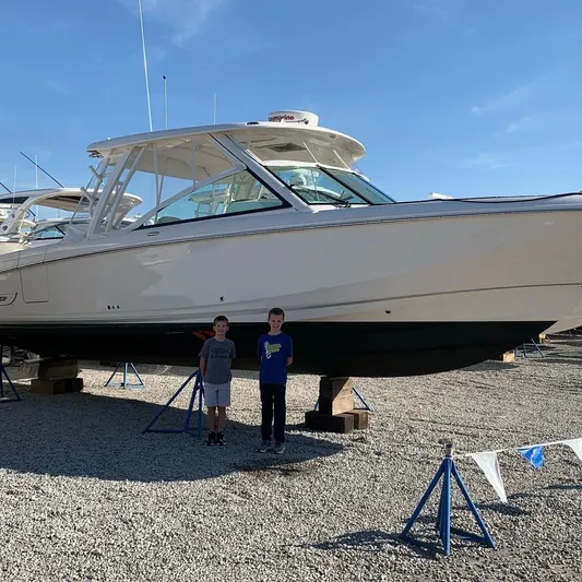  Yacht Photos Pics Two children standing in front of a 2020 Boston Whaler 320 Vantage boat.