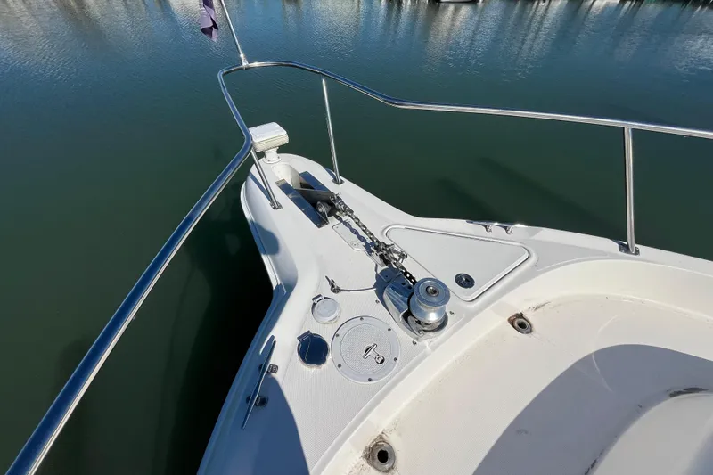 A Friend Like Me Yacht Photos Pics Bow of 2000 Sea Ray 460 Sundancer yacht with anchor and railing in calm water.
