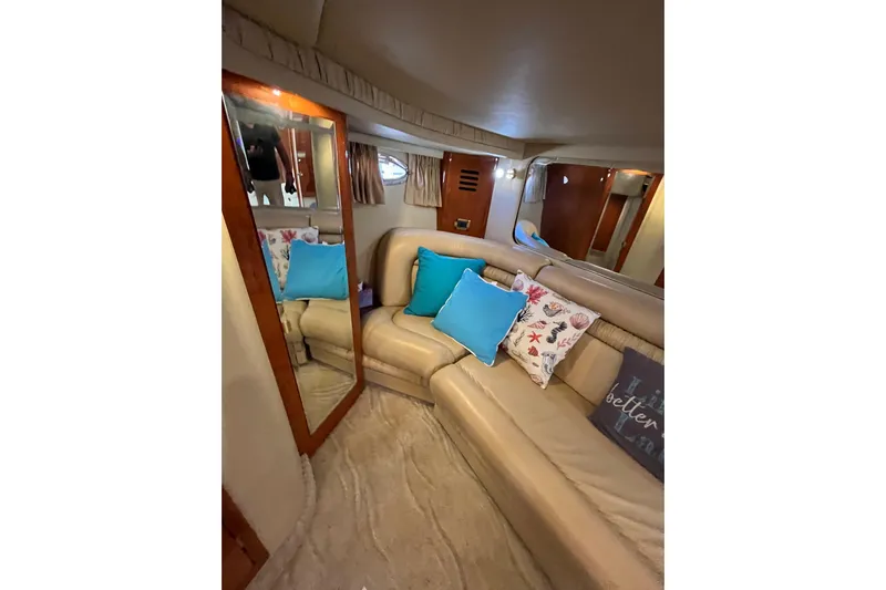 A Friend Like Me Yacht Photos Pics Interior of 2000 Sea Ray 460 Sundancer with beige seating and colorful cushions.