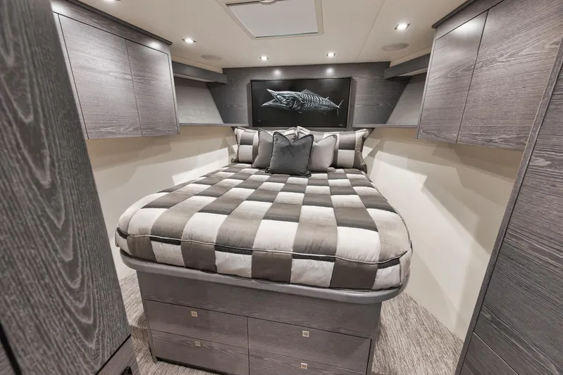 Lady Surfbum Yacht Photos Pics Luxurious bedroom interior of 2024 Viking 72 Convertible yacht with modern design and checkered bedding.