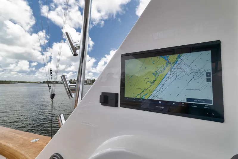 Lady Surfbum Yacht Photos Pics 2024 Viking 72 Convertible yacht with Garmin navigation display, docked by calm waters under a cloudy sky.