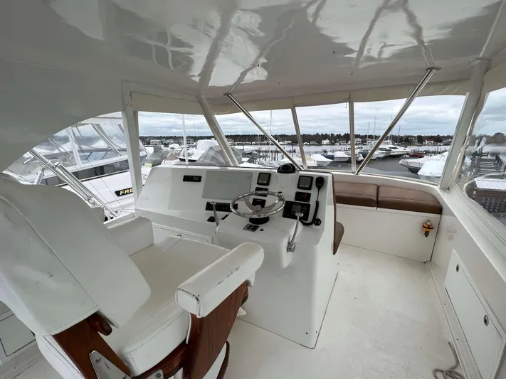  Yacht Photos Pics Helm station of 2021 Henriques 50 Sportfisherman with white captain's chair and navigation equipment.
