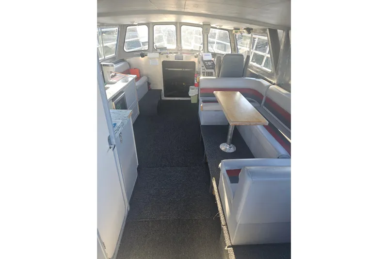 Gig Yacht Photos Pics Interior of 1994 Custom SMW 38 boat with seating, table, and kitchenette.