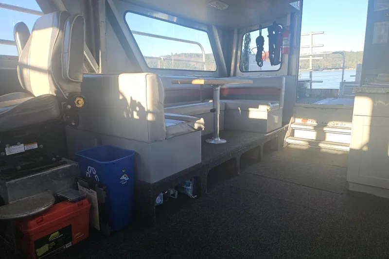 Gig Yacht Photos Pics Interior of a 1994 Custom SMW 38 boat with seating and table, dockside view.