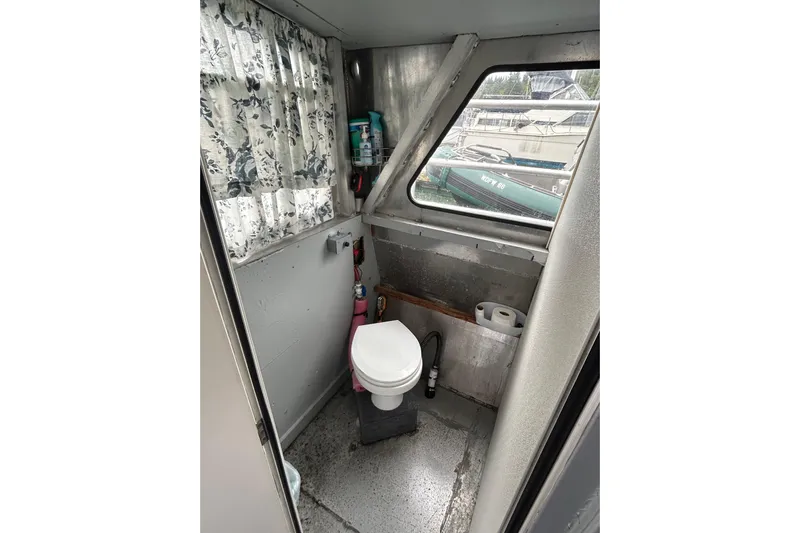 Gig Yacht Photos Pics Small boat bathroom with toilet, floral curtains, and window on a 1994 Svendsen Marine Works SMW 38.