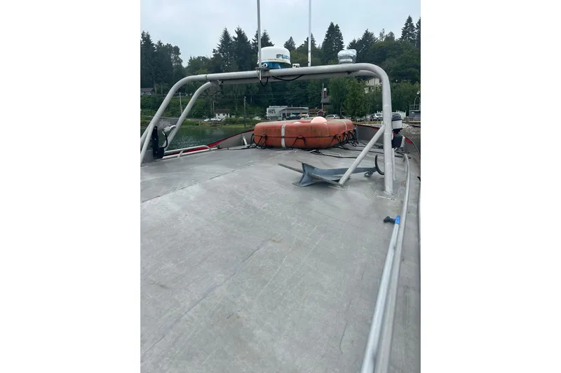 Gig Yacht Photos Pics 1994 Svendsen Marine Works SMW 38 boat deck with lifebuoy and anchor, docked near trees.