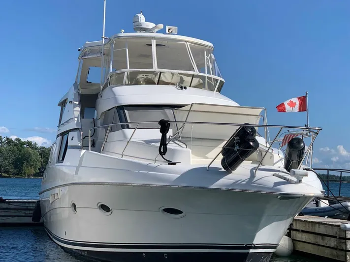  Yacht Photos Pics 2000 Silverton 453MY yacht docked, featuring a Canadian flag and clear blue sky.