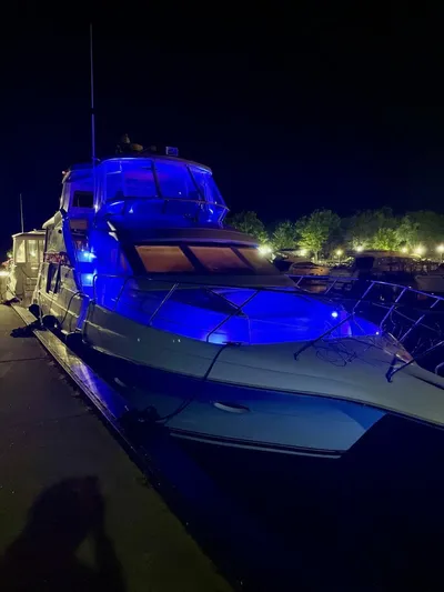  Yacht Photos Pics 2000 Silverton 453MY yacht illuminated with blue lights at night, docked by the shore.