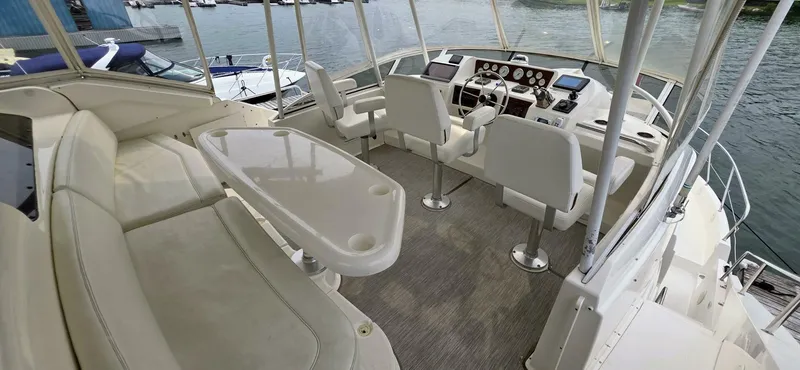  Yacht Photos Pics 2000 Silverton 453MY yacht interior with helm, seating, and table on a sunny day.