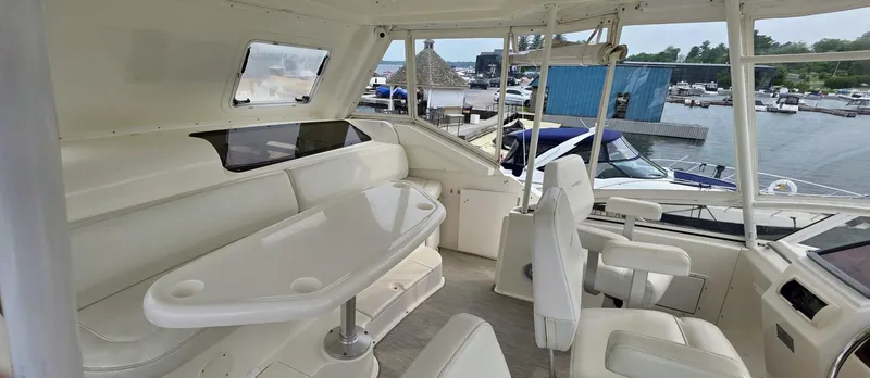  Yacht Photos Pics Interior of 2000 Silverton 453MY yacht with white seating and table, docked at marina.