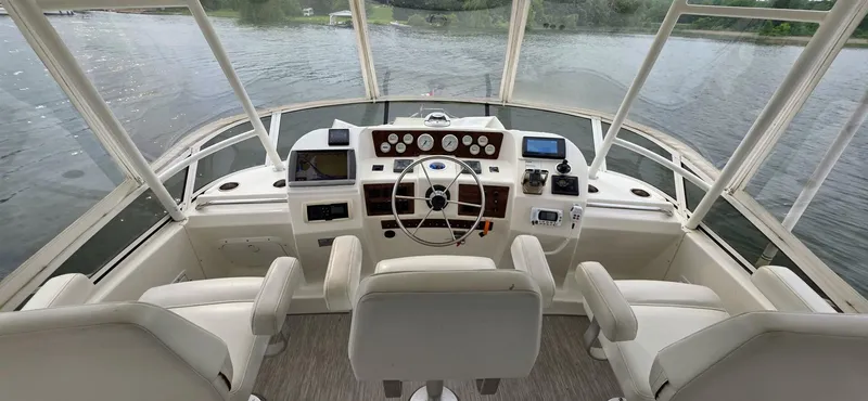  Yacht Photos Pics 2000 Silverton 453MY yacht helm with three seats, overlooking calm waters.